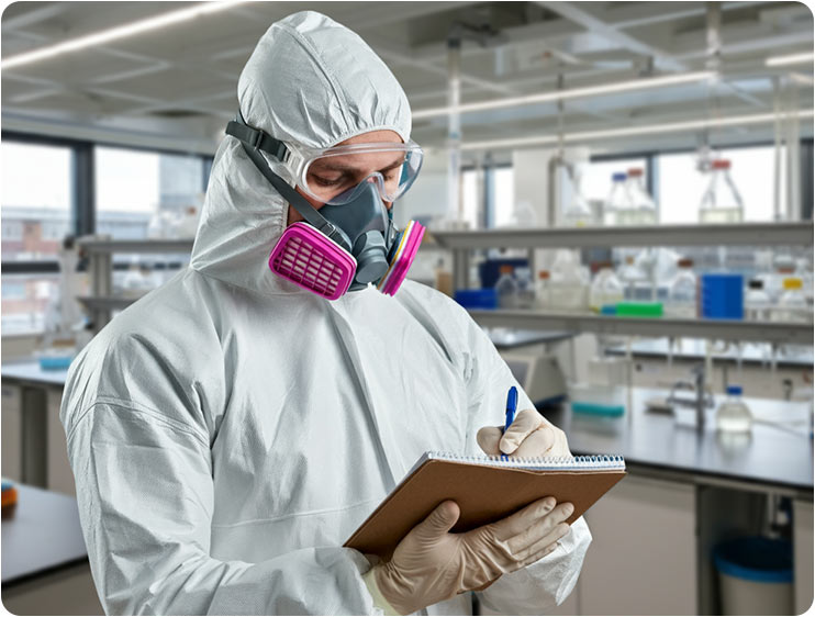 Técnico documentando procesos de desinfección en laboratorio con equipo de protección especializado.